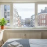 Bright urban bedroom with desk and window view; Rent a Room Cheap Near Me: 2026 Guide to Affordable Housing.