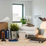 Apartment Shopping List: Your Complete 2026 Essentials Guide featuring boxes, tools, and a man using a tablet.