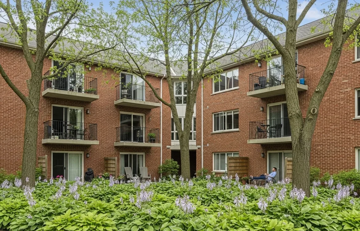 Lush greenery around a low-rise building showing why are they called garden apartments with manicured lawns.