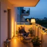 Cozy evening setup featuring warm apartment balcony lighting with string lights and modern floor lanterns.