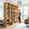 Modern storage wall for studio apartment layout designed to maximize living space and efficiency.