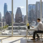 Modern interior of Waller Apartments Austin featuring a professional workspace with a view of the city skyline.