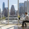 Modern interior of Waller Apartments Austin featuring a professional workspace with a view of the city skyline.
